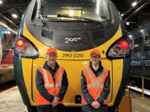 Two people stood in front of a train