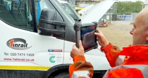 A man holding a device near a van