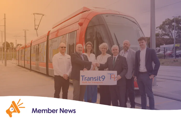A group of people holding a sign in front of a train