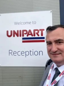 A man taking a selfie with the Unipart logo