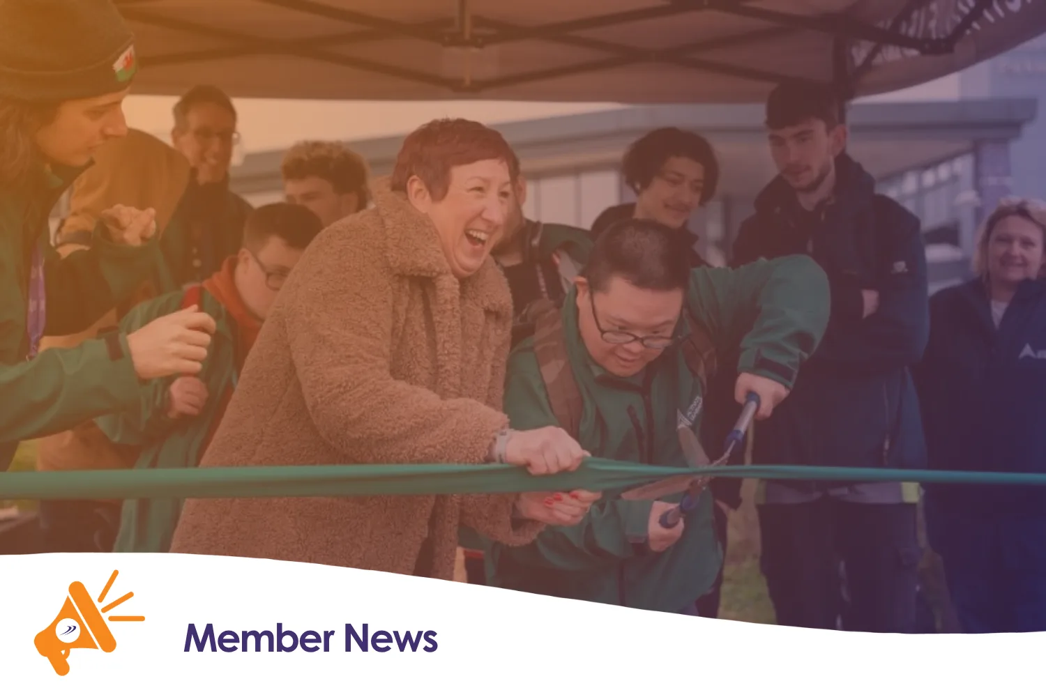 Two people cutting a ribbon