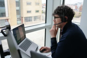 A man working on a laptop wearing headphones