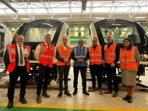 A group of people stood in front of two trains