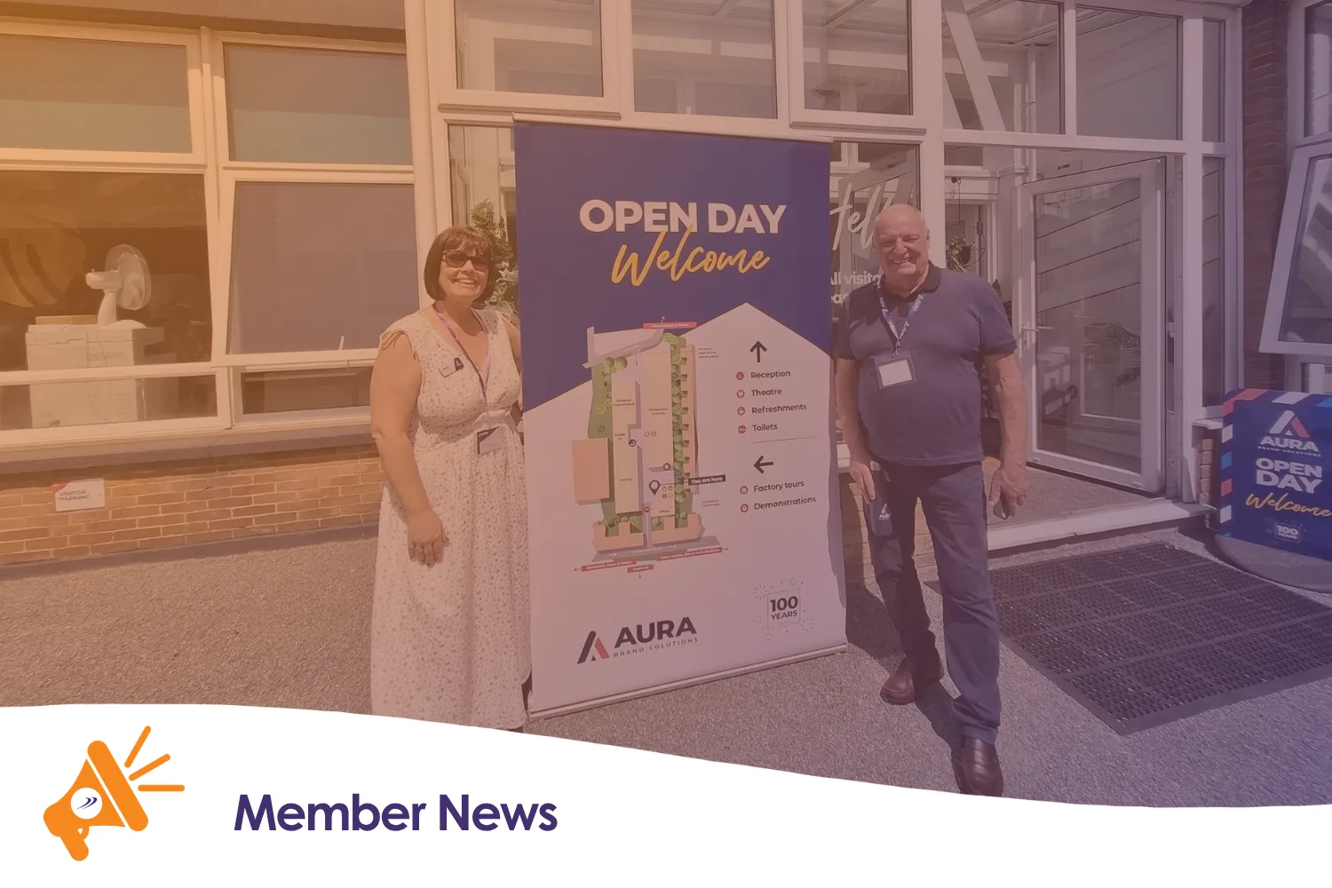 Two people stood in front of an open day sign
