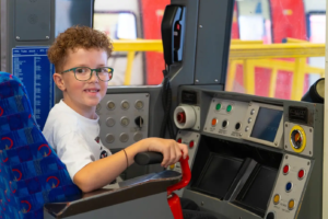 A child in a train driver's seat