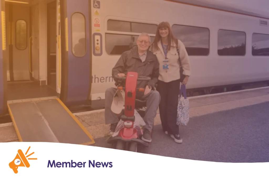 Two people stood next to a Northern train